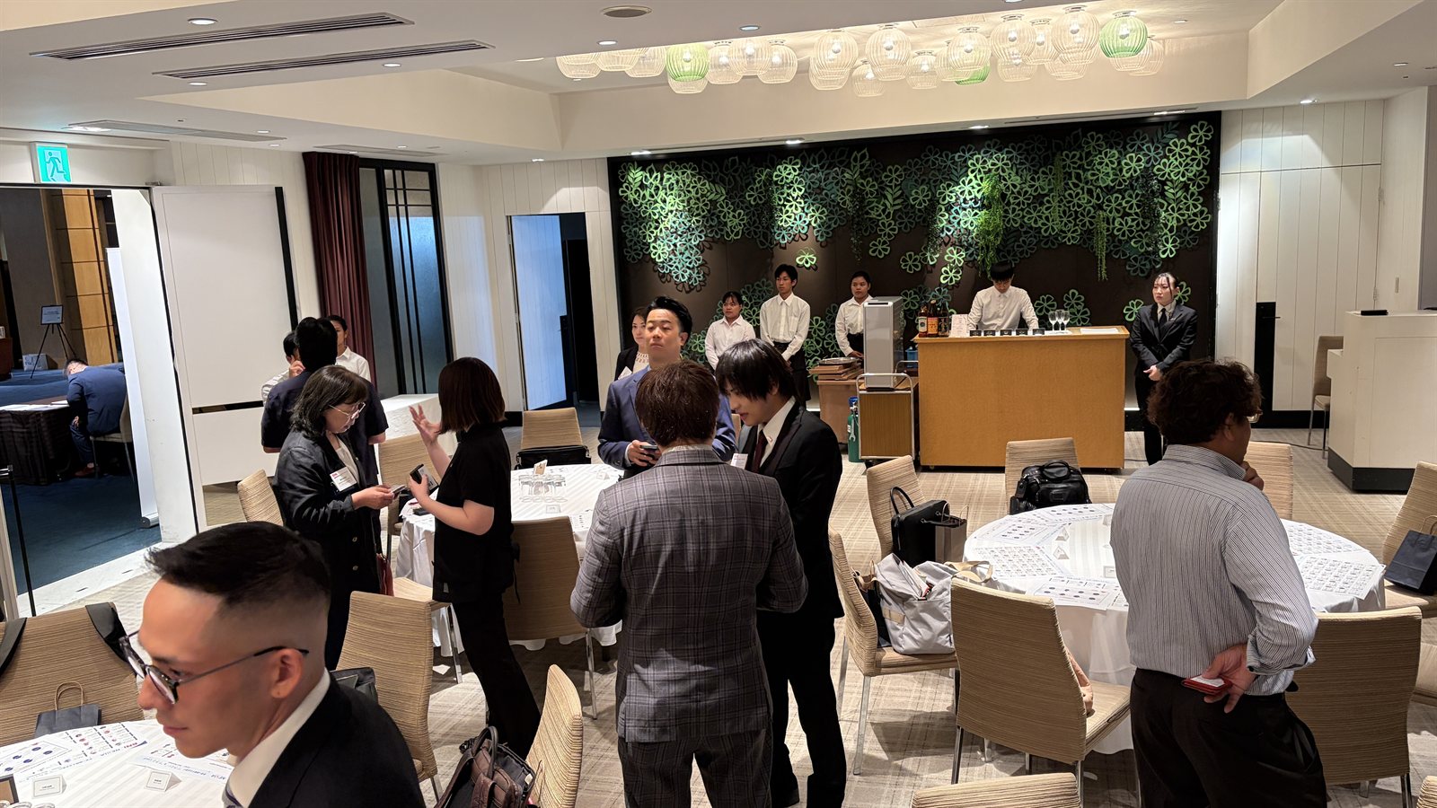Guests networking at the founding celebration, exchanging business cards and talking in small groups